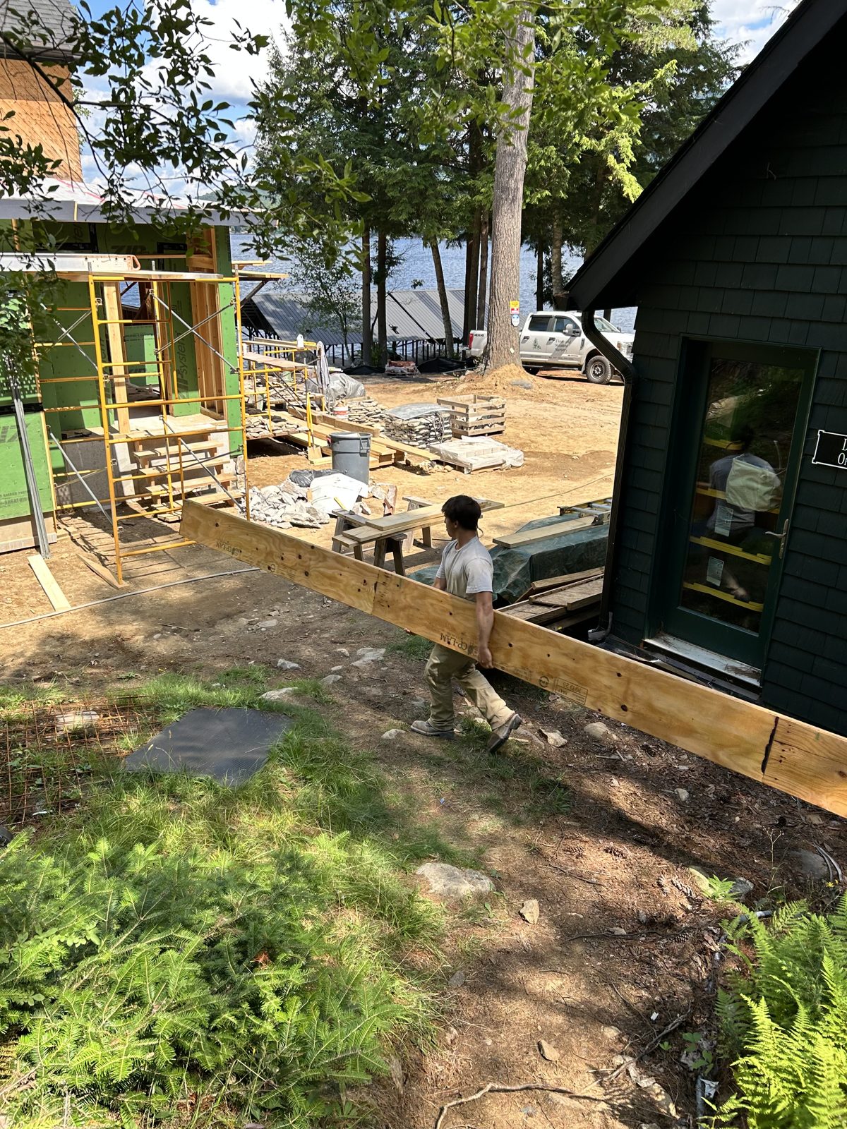 A crew building a deck at a camp in the woods